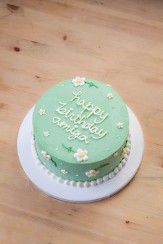 a green birthday cake sitting on top of a wooden table