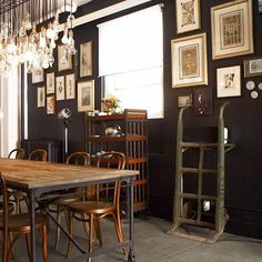 a dining room table with chairs and pictures on the wall