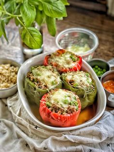 some stuffed peppers are on a plate with sauces and seasonings next to them