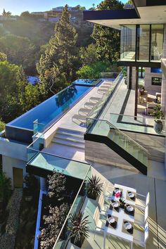 an aerial view of a modern house with pool and trees in the back ground area