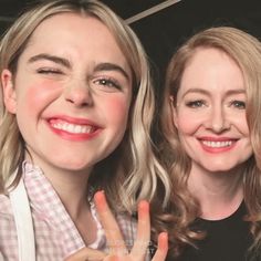 two women smiling and making the peace sign