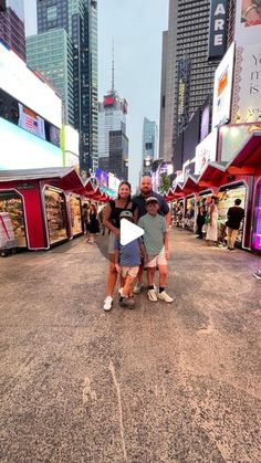 three people standing in the middle of a street