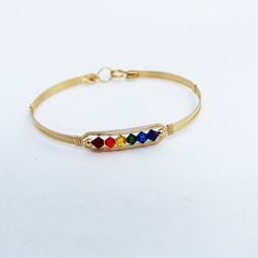 A sweet little bracelet of five strands of 14kt gold filled wire with a center design featuring five 4mm crystal bicone beads in a rainbow design. Accented with two smaller beads.   The bracelet's joyful and expressive design celebrates inclusivity and serves as a reminder to embrace authenticity.  Whether you identify as LGBTQ+ or simply love the enchanting allure of rainbows, this statement bracelet allows you to express your true colors with confidence and style.  Plus the multi colors will g Rainbow Crystal Bracelet, Wire Bangles, Rainbow Crystal, Gold Necklace Designs, Gold Bangle Bracelet, Stackable Bracelets, Rainbow Design, Statement Bracelet, Gold Bangles