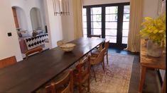 a dining room table and chairs in front of a doorway