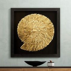 a black bowl sitting on top of a wooden table in front of a framed artwork