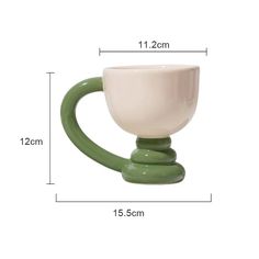 a white cup sitting on top of a green handle