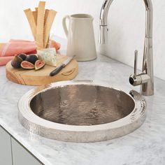 a kitchen sink sitting on top of a counter next to a cutting board and knife