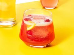 two glasses filled with drinks sitting on top of a yellow table