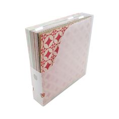 a pink binder with red and white designs on the cover is shown in front of a white background