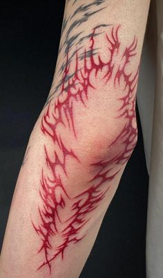 a person with red and black tattoos on their arm