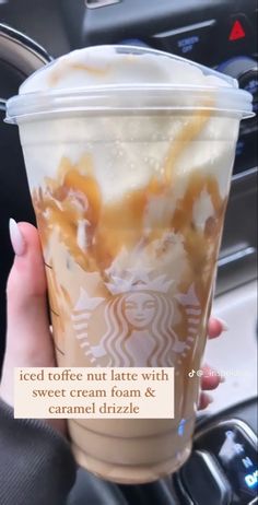 a woman holding up a starbucks cup with caramel drizzle on it's side