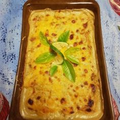 a casserole dish with green leaves on top