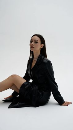 a woman sitting on the ground wearing black clothes