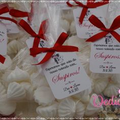 some white chocolates wrapped in red ribbon and tied with bows are on display for someone's special occasion