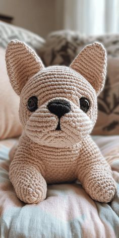 a crocheted dog sitting on top of a bed