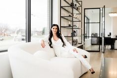 a woman sitting on top of a white couch