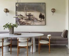 a white table and chairs in a room with a painting on the wall behind it