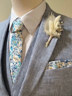 a man wearing a suit and tie with a boutonniere on his lapel