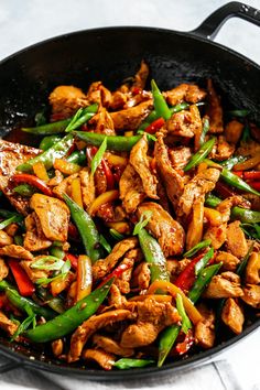 a skillet filled with chicken and green beans