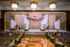 the stage is decorated with pink flowers and gold decorations for an event or wedding reception