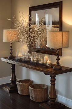 Elegant wooden console table with decorative lamps and cherry blossom branches flanked by two wicker baskets. Foyer Tables Entryway Bohemian, Tuscan Entry Table, Gold Entryway Table Farmhouse, Entry Eay Table, 2022 Entrway Table, Grand Farmhouse, Entryway Table Ideas, Organized Entryway, Diy Entryway Table