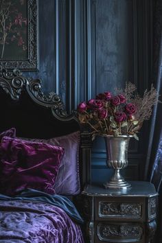 a bed with purple sheets and flowers in a silver vase