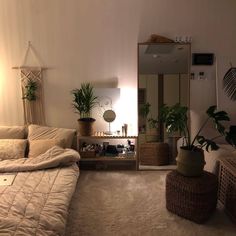 a bedroom with a bed, mirror and plants