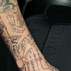 a close up of a person's arm with tattoos on it