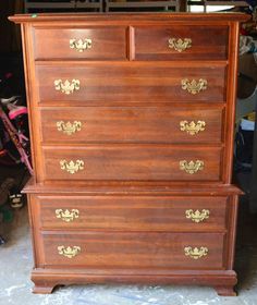 an old wooden dresser with gold handles and knobs on the top, sitting in a garage