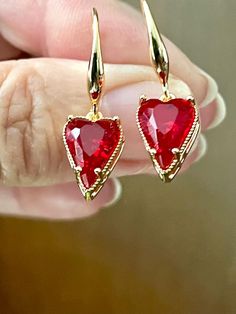 These lovely red faceted glass hearts are set in gold finish slightly elongated heart-shaped claw setting and make the perfect gift for Mother's Day, birthdays, anniversaries or Valentine's Day. They hang on gold plated ear wires.  See photo 4 for an idea of size. The drop is just over half an inch. These romantic earrings make a wonderful gift year round and will be packaged in an organza bag ready for gift giving.  Holiday Happy Dance is a festive and fun jewelry collection that celebrates holidays and occasions throughout the year. A percentage of all net sales is donated to charities that support vulnerable children. Please check out my other festive designs at holidayhappydance.etsy.com and my coastal-inspired collections at EJMDesigns.etsy.com Thanks for looking, and for supporting m Red Heart-shaped Earrings For Her, Red Heart Pendant Earrings For Anniversary, Heart-shaped Earrings For Valentine's Day Formal, Red Heart Earrings For Valentine's Day Anniversary, Heart Shaped Earrings For Valentine's Day Formal, Heart Shaped Earrings For Valentine's Day And Formal Occasions, Teardrop Earrings For Valentine's Day Anniversary, Formal Heart Charm Earrings For Valentine's Day, Formal Heart Earrings For Valentine's Day