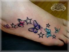 a woman's foot with butterflies and stars on it