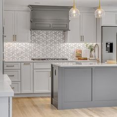 a kitchen with gray cabinets and white counter tops