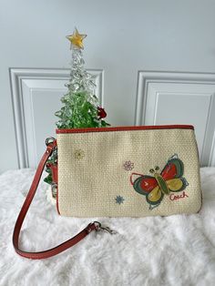 This Coach wristlet is a stunning piece that features a floral and butterfly theme adding an extra pop of glamour. The exterior is made of light beige straw , while the leather strap adds a bold touch of orange. The wristlet is the perfect size for everyday use. Inside, there are inner pockets to keep your items organized, and the lining is yellow. The bag is pre-owned but in excellent condition. Whether you're running errands or heading out for a night on the town, this wristlet is a stylish and practical accessory. **Please keep in mind product color may slightly vary due to photographic lighting sources or your monitor settings***** We encourage thoroughly checking the listing, descriptions, and shipping. If you have any questions, please message me directly. After I drop the package of Leather Butterfly, Butterfly Theme, Coach Wristlet, Butterfly Flowers, Photographic Lighting, Light Beige, Running Errands, Patent Leather, Bags Handbags