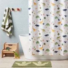 a shower curtain with dinosaurs on it in a child's bathroom, next to a toy dinosaur