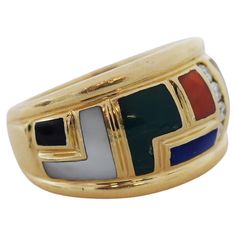 Wide band ring is inlaid to front with a mosaic of calibré cut gemstones Featuring ultramarine lapis lazuli, green chalcedony, white mother-of-pearl, black onyx, and orange coral Channel of round brilliant cut diamonds weigh in total approximately 0.12 carat - G/H color with VS clarity With deeply grooved edges Stamped 14K for 14 karat gold Fully signed Asch Grossbardt with maker's mark Circa: 1990s Ring Size: 6 Approx. Wide 12.5 mm Total weight: 10 grams Colorful Geometric design IN great preow Orange Gemstone Ring, Wide Band Ring, Green Chalcedony, Orange Coral, Wide Band Rings, Maker's Mark, Wide Bands, G H, Round Brilliant Cut Diamond