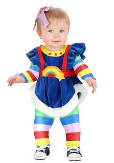 a baby girl dressed in a clown costume with a rainbow on it's chest