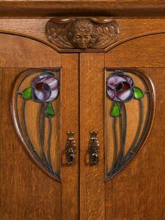 an ornate wooden cabinet with stained glass flowers on the front and side panels, along with metal handles