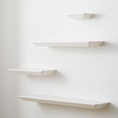 three white shelves are lined up against the wall