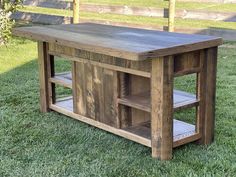 a wooden table sitting on top of a lush green field