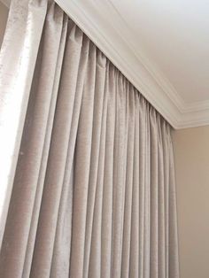 the curtains are pulled back to let light into the room, and it looks like they could be drapes