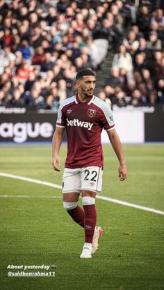 a soccer player is on the field during a game with an audience in the background