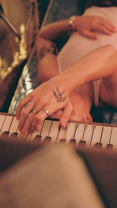 two people touching each other's fingers while sitting at a piano keyboard with their hands on the keys