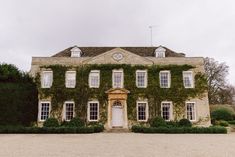 an old house with ivy growing all over it's sides and windows on the front