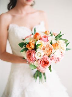 a bride holding a bouquet of flowers in her hand and looking at the camera with an intense look on her face