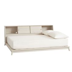 a bed with a white headboard and pillows on it's sides, against a white background