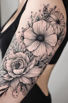 a woman's arm with black and white flowers on the left side of her body