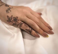 a woman's hand with a flower tattoo on it