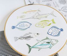 an embroidery project with fish on it and some other items in front of the hoop