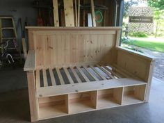 a bed frame made out of wood in a garage