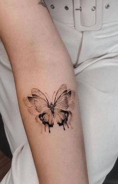 a woman's arm with a butterfly tattoo on the left side of her arm